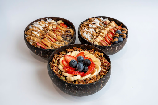 Three colorful acai bowls placed next to each other.
